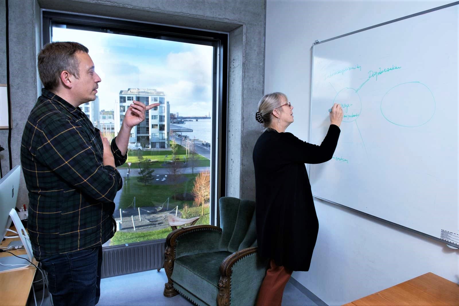 Thomas Ryberg and Anette Kolmos are working on a white board.